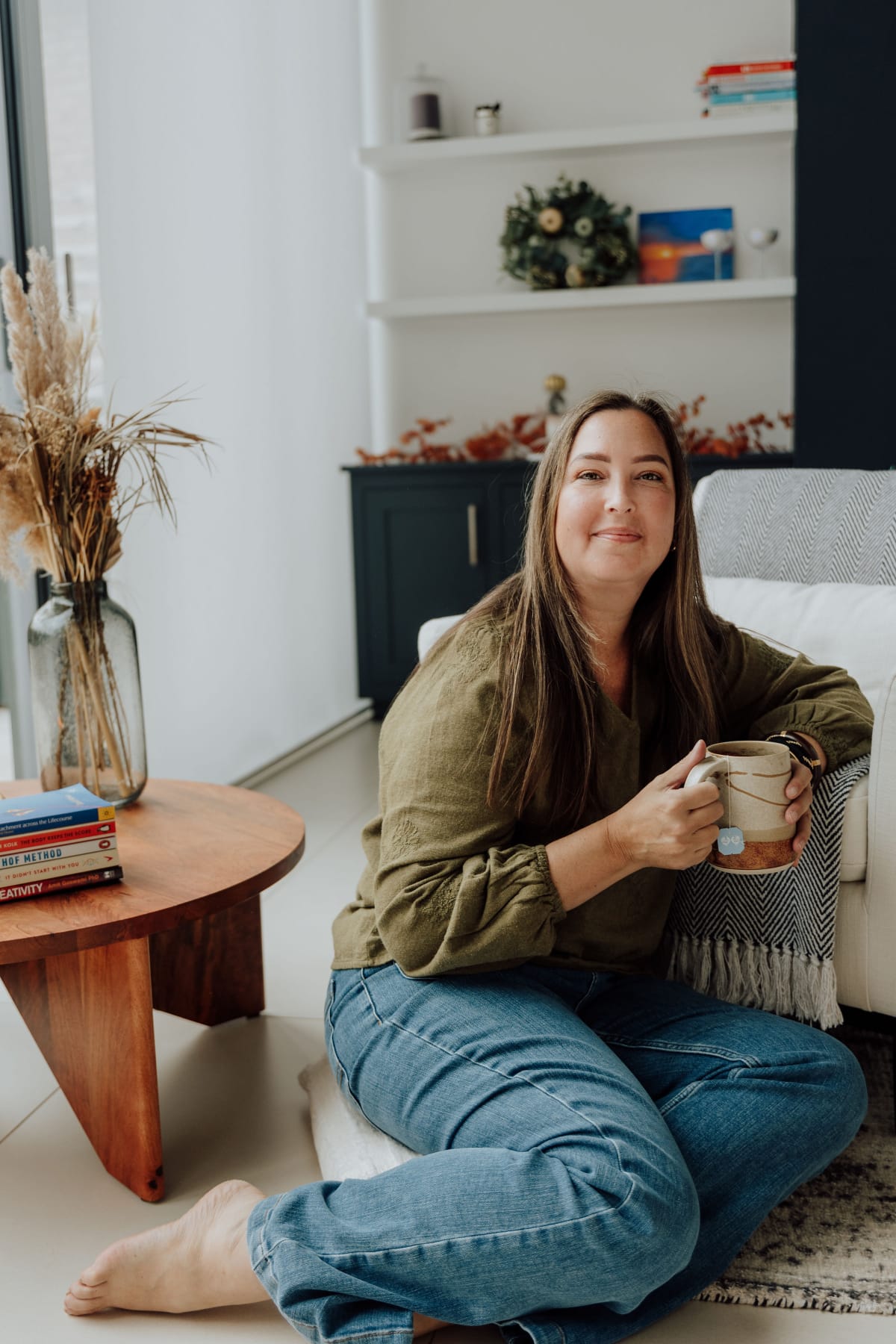 Melody Robinson sitting with a mug, offering a warm and inviting space for emotional healing and personal transformation.